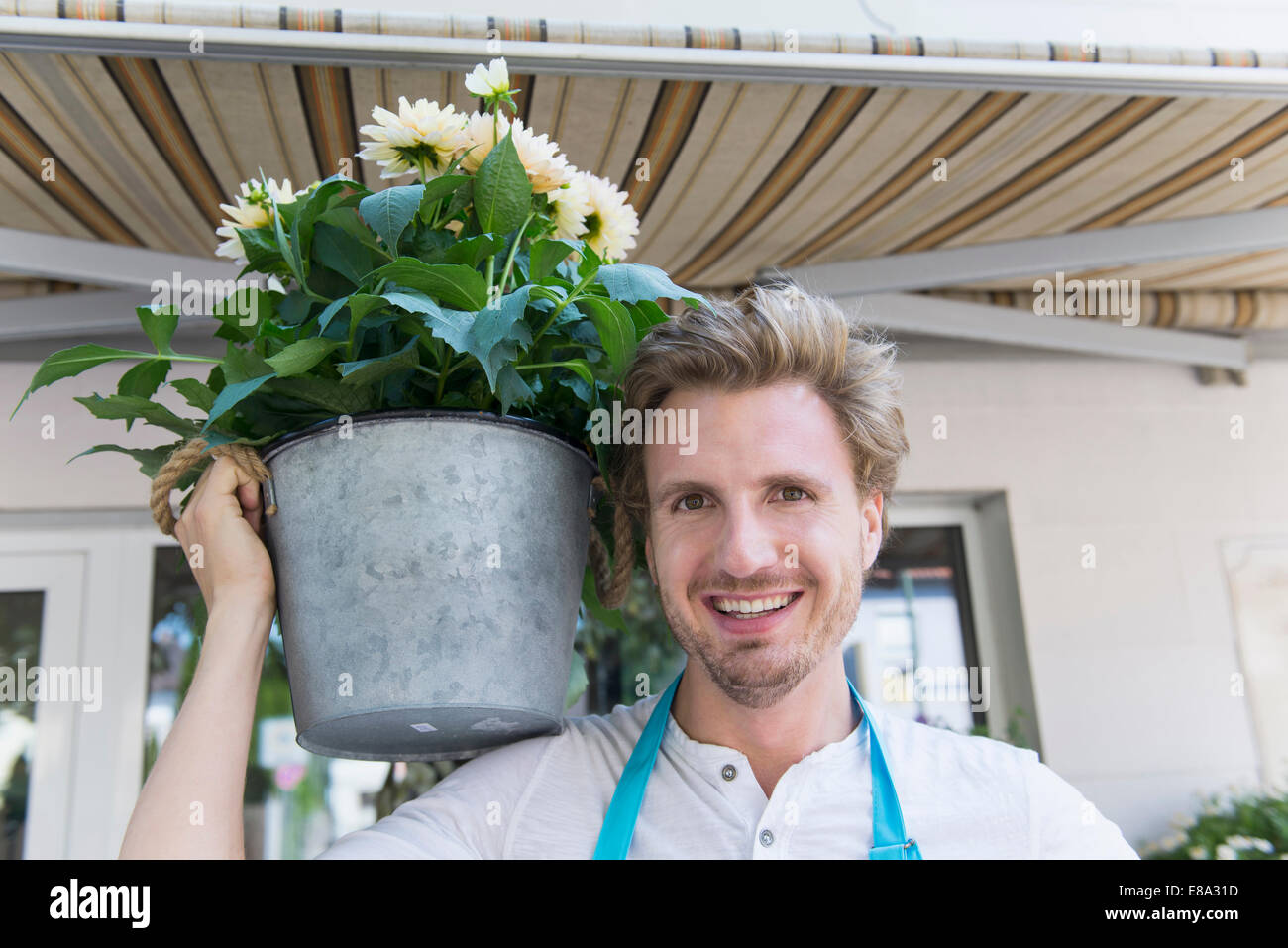 Portrait of mid adult man holding potted plant of flower, smiling Stock ...
