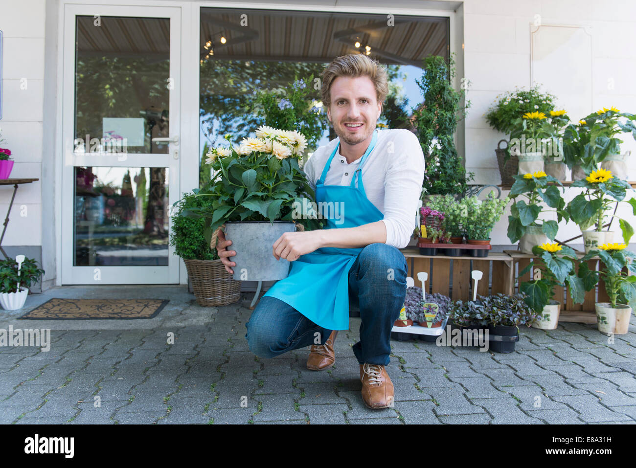Portrait of mid adult man holding potted plant of flower, smiling Stock ...