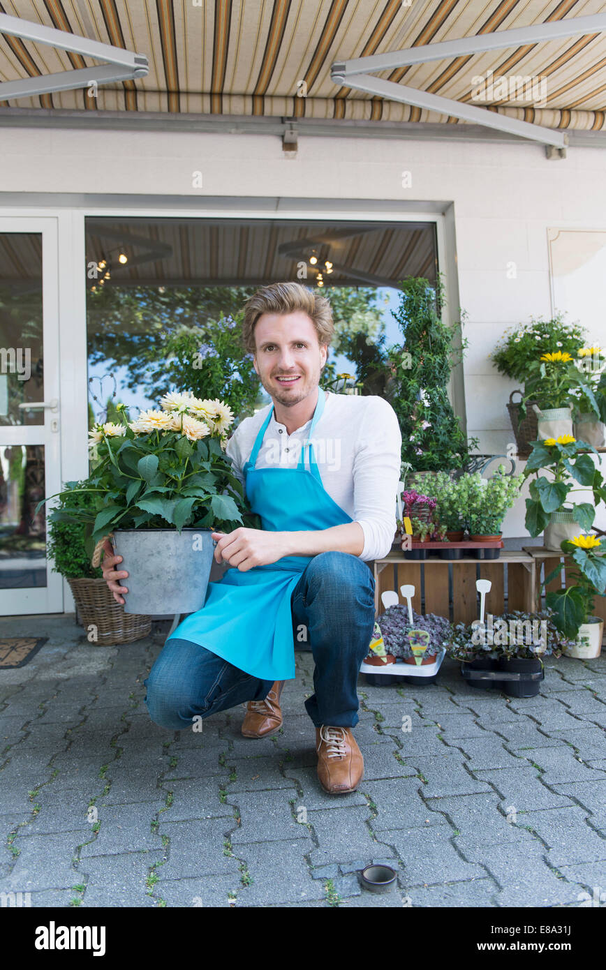 Portrait of mid adult man holding potted plant of flower, smiling Stock ...