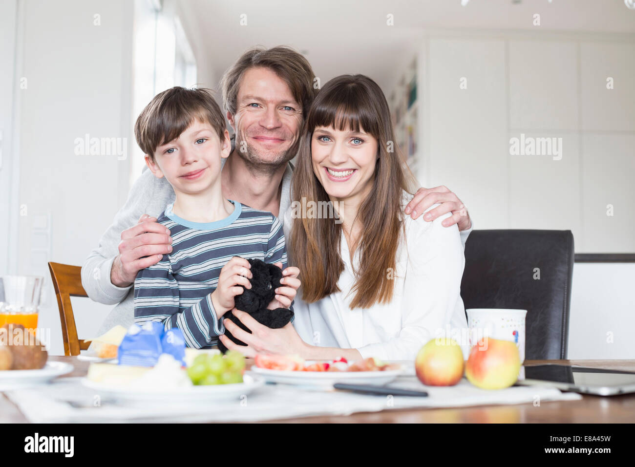 Portrait of family at breakfast table, smiling Stock Photo - Alamy