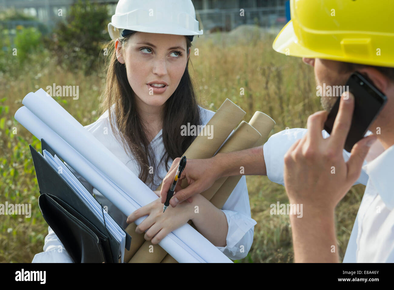 Architect writing on assistant's hand Stock Photo Alamy