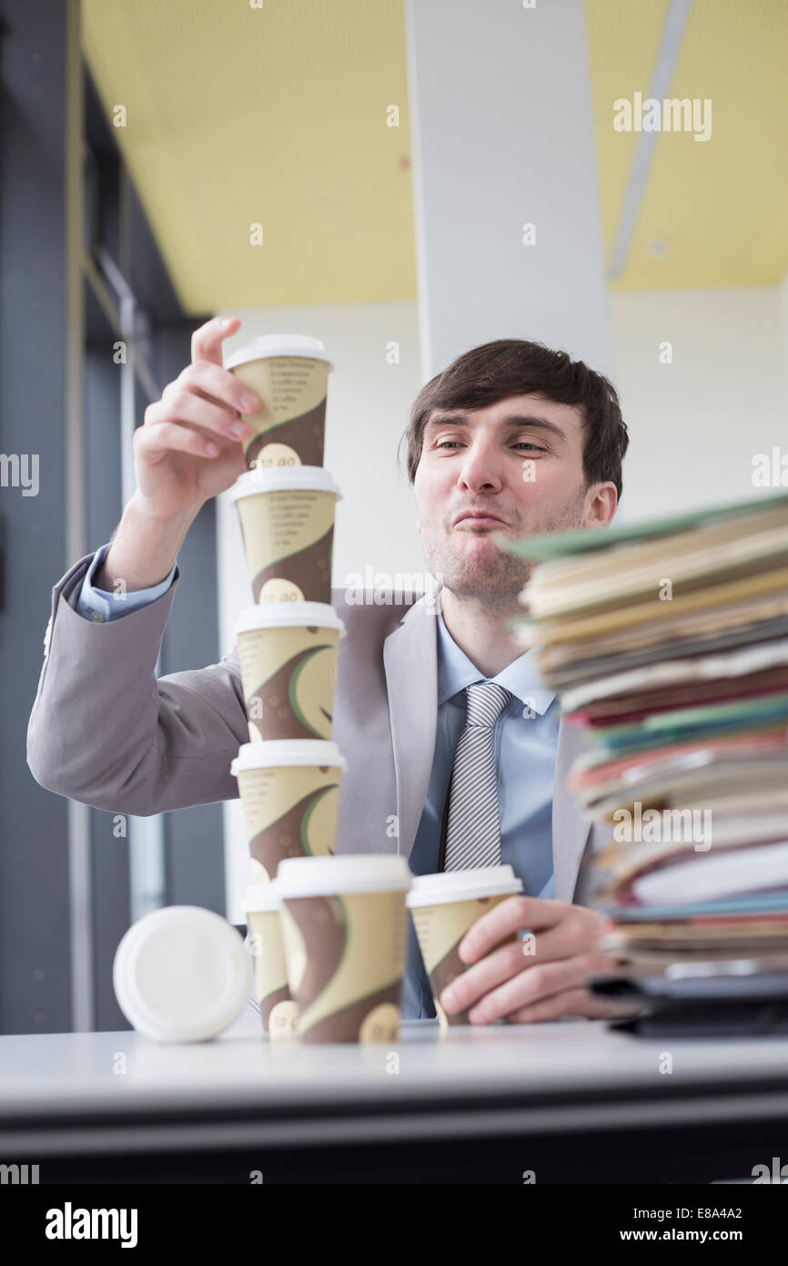 businessman building tower with coffee cups, smiling Stock Photo