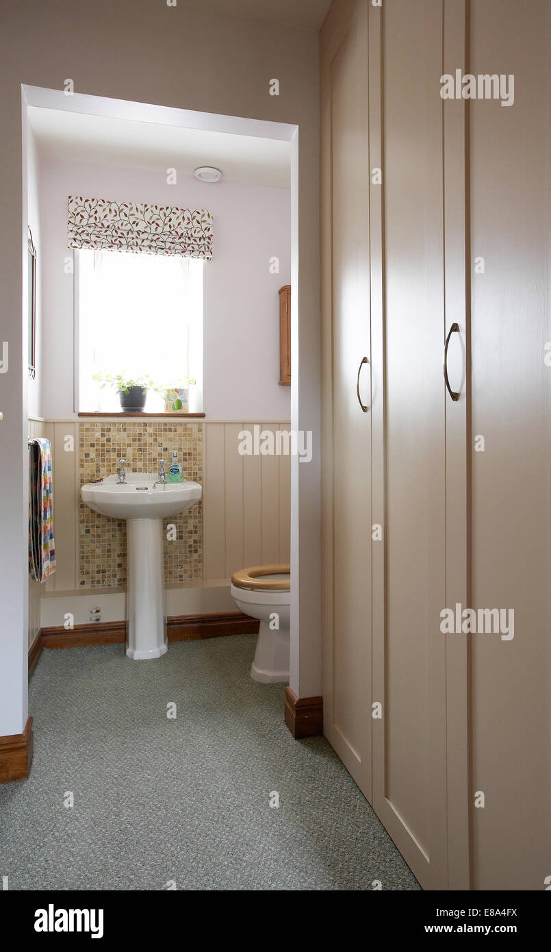 A downstairs cloakroom toilet and handbasin in a home in the UK Stock
