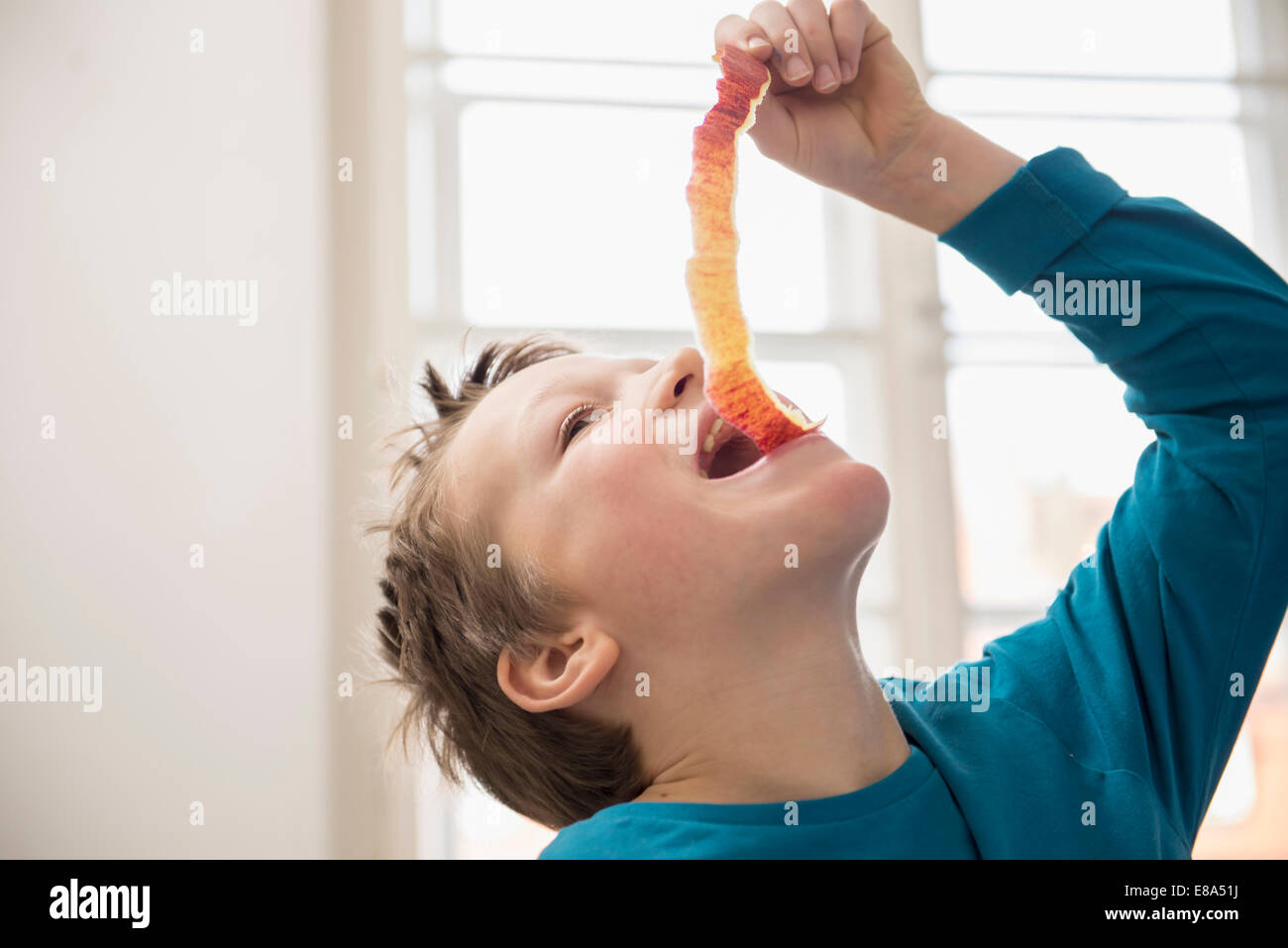 Boy eating long apple peel Stock Photo Alamy