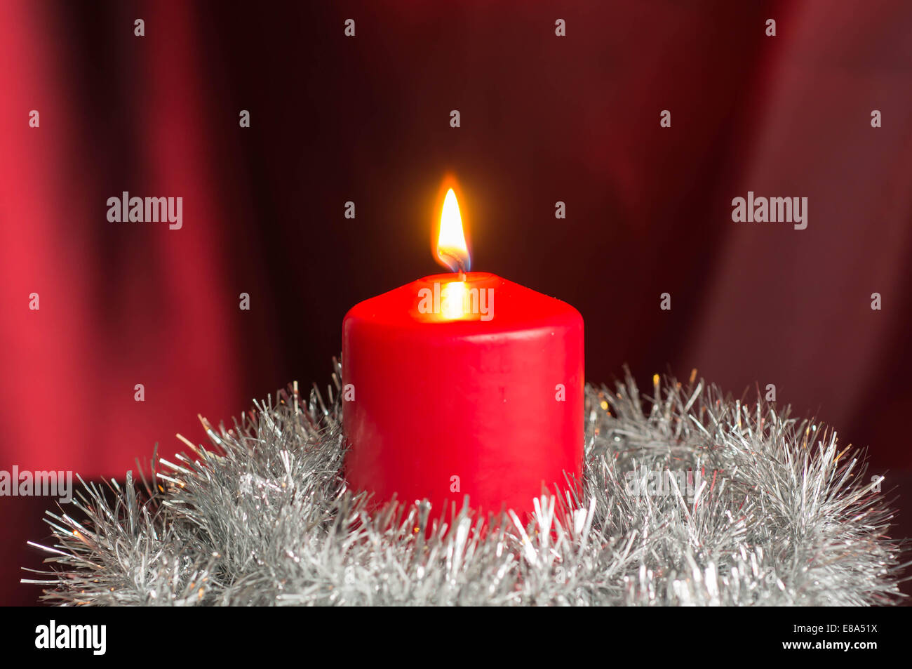 Red candle with a silvery Christmas decor Stock Photo