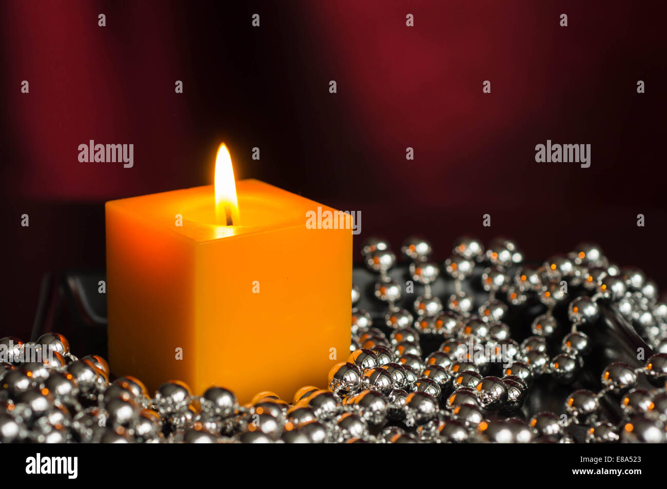 Yellow candle with a decor from silver balls Stock Photo Alamy