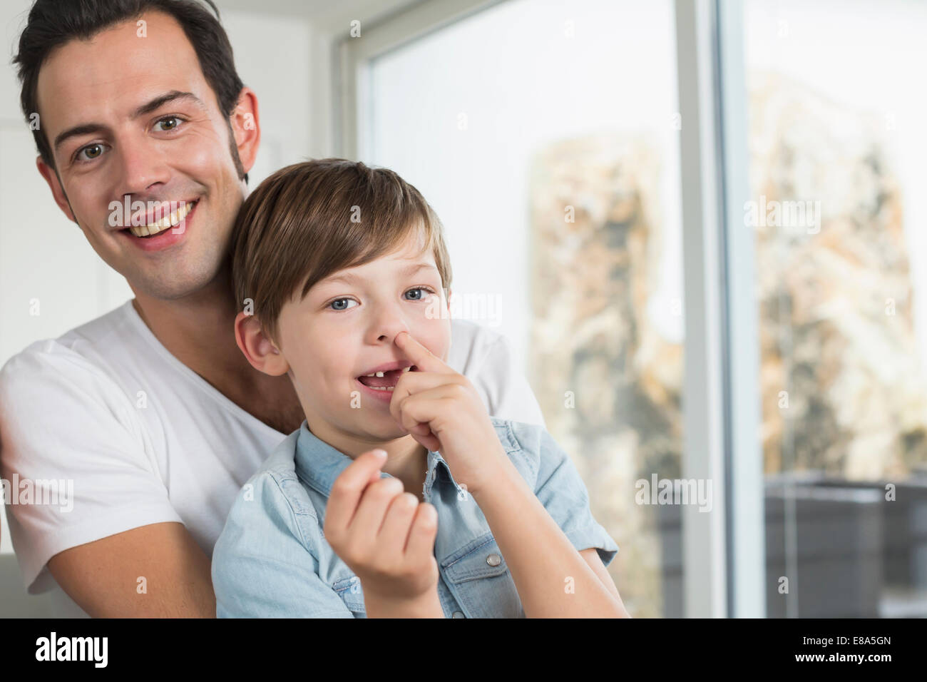 Smiling father with son picking nose Stock Photo