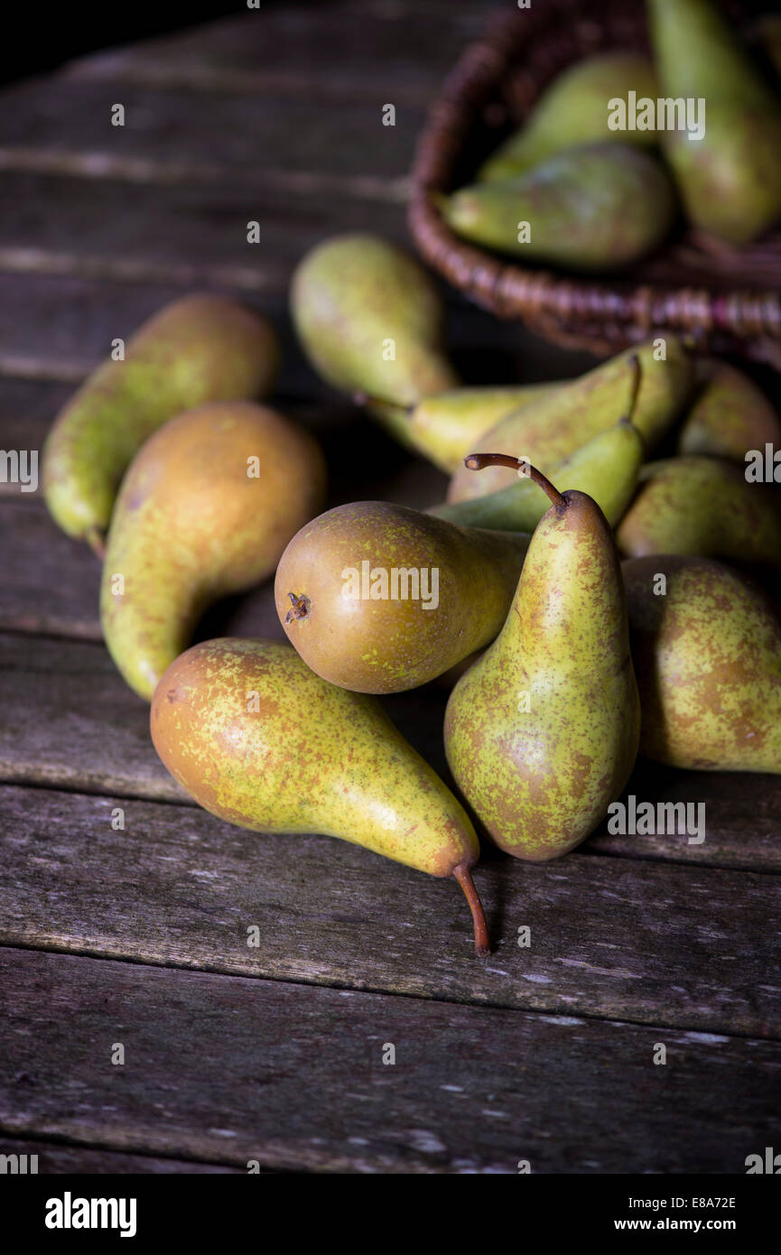 Pyrus. Pears and wicker basket on a wooden table Stock Photo