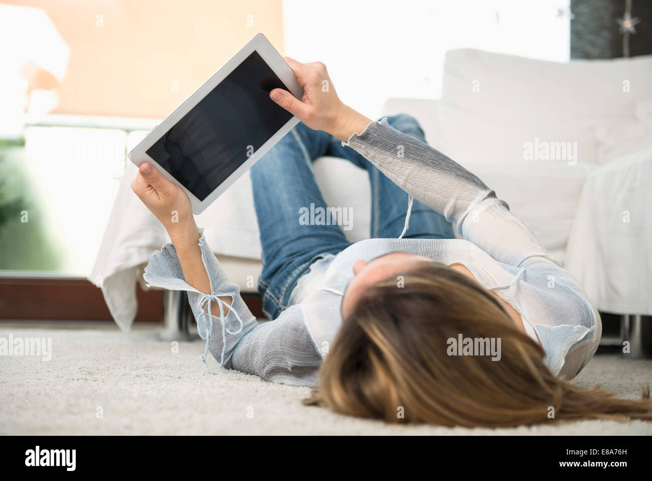 Woman lying on back with digital tablet Stock Photo - Alamy