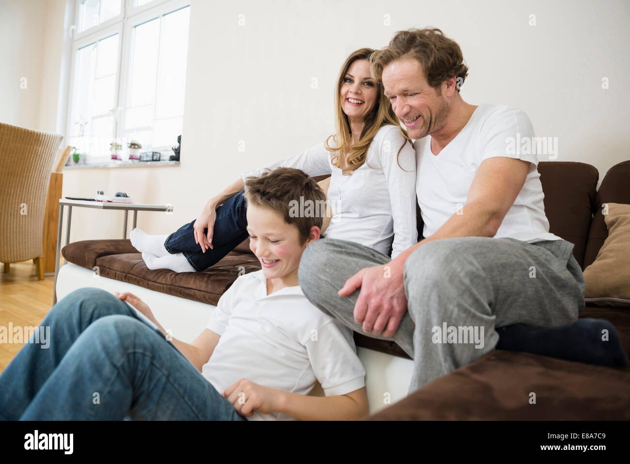 Happy family in living room with digital tablet Stock Photo