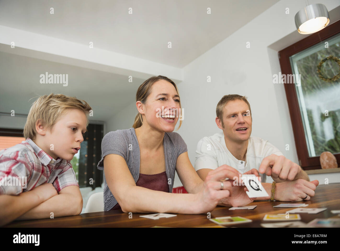 Family at living room playing parlor game together Stock Photo