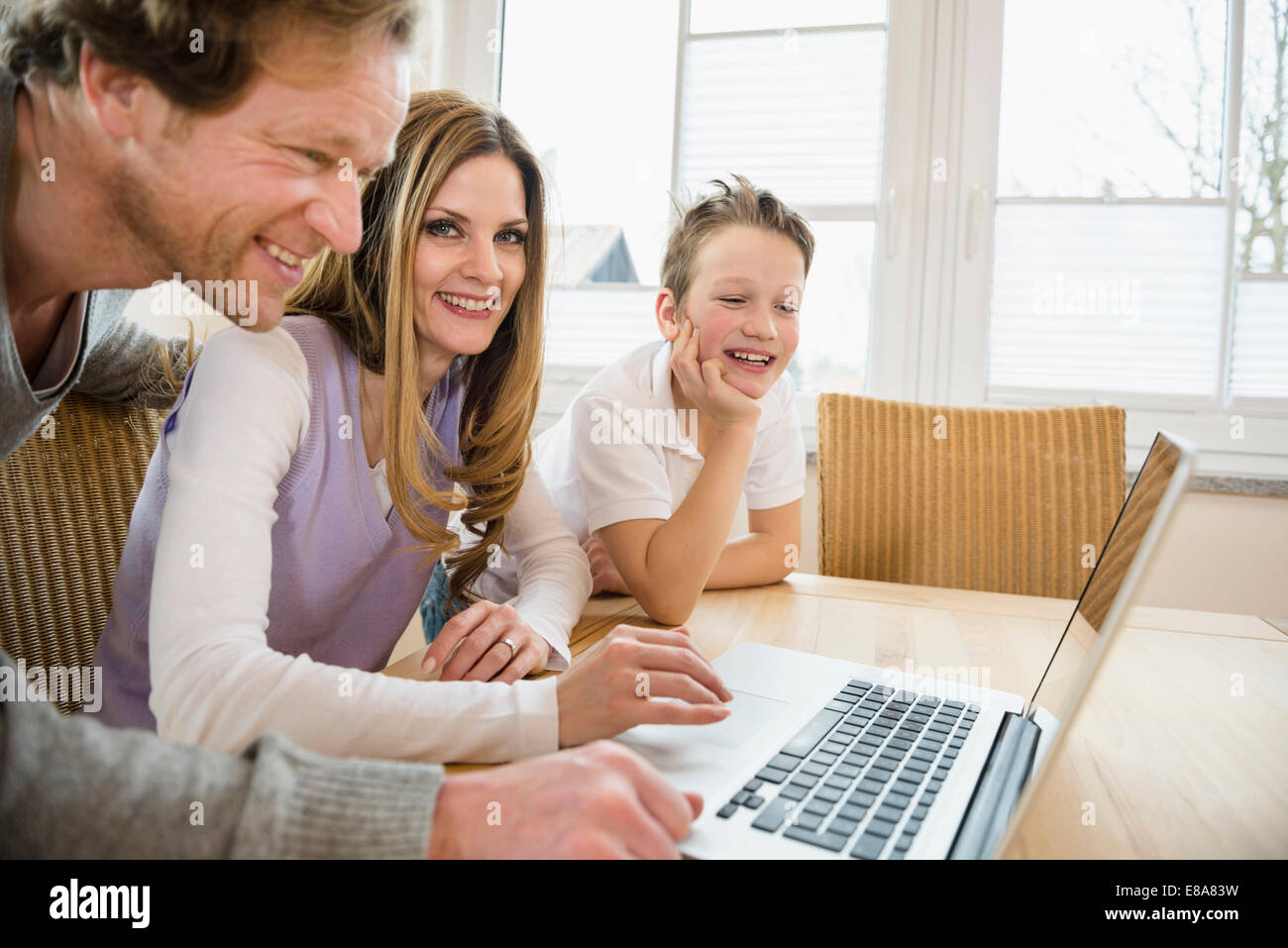 Family using laptop at home Stock Photo - Alamy
