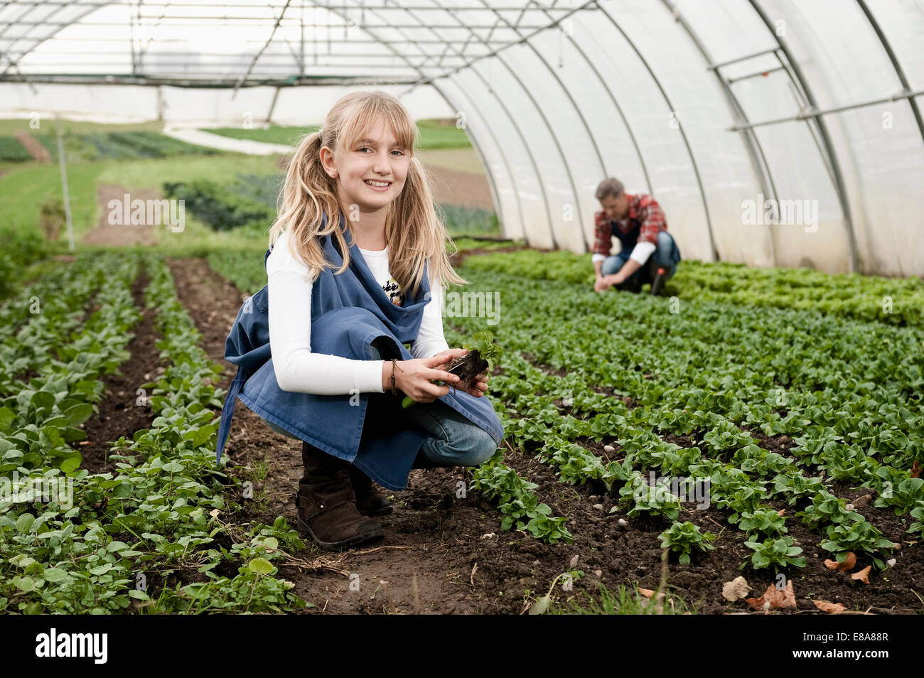 Smiling blond girl in greenhouse Stock Photo - Alamy