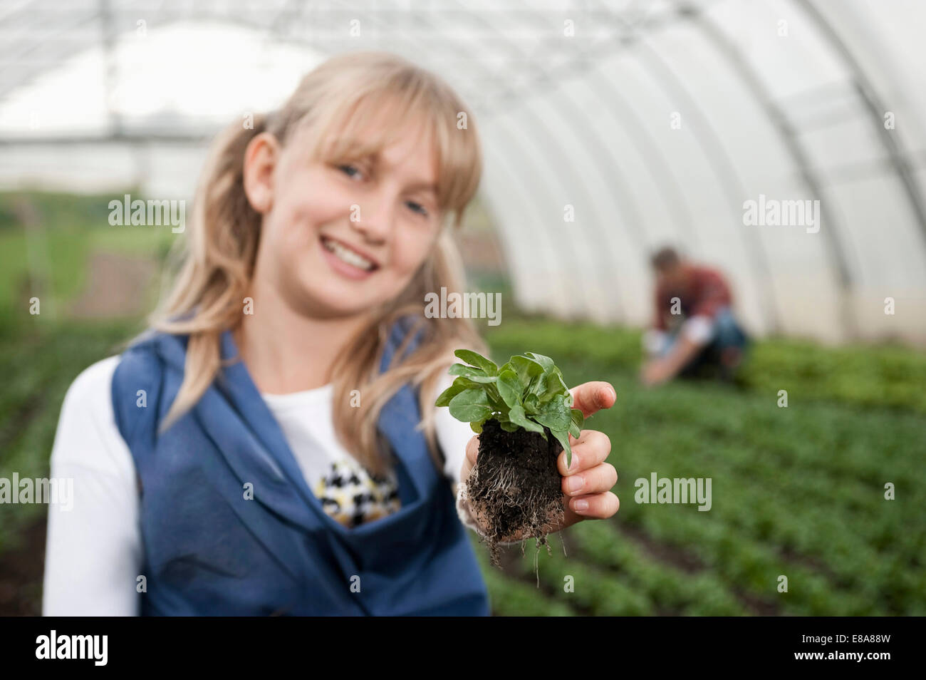 Smiling blond girl in greenhouse Stock Photo - Alamy