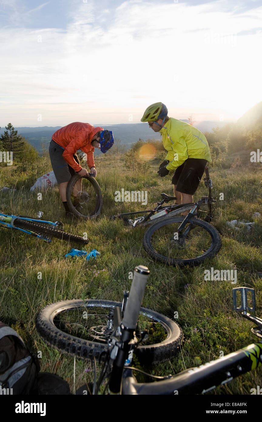 two mountain bikers repairing bicycle tyre, Vipava valley, Istria, Slovenia Stock Photo
