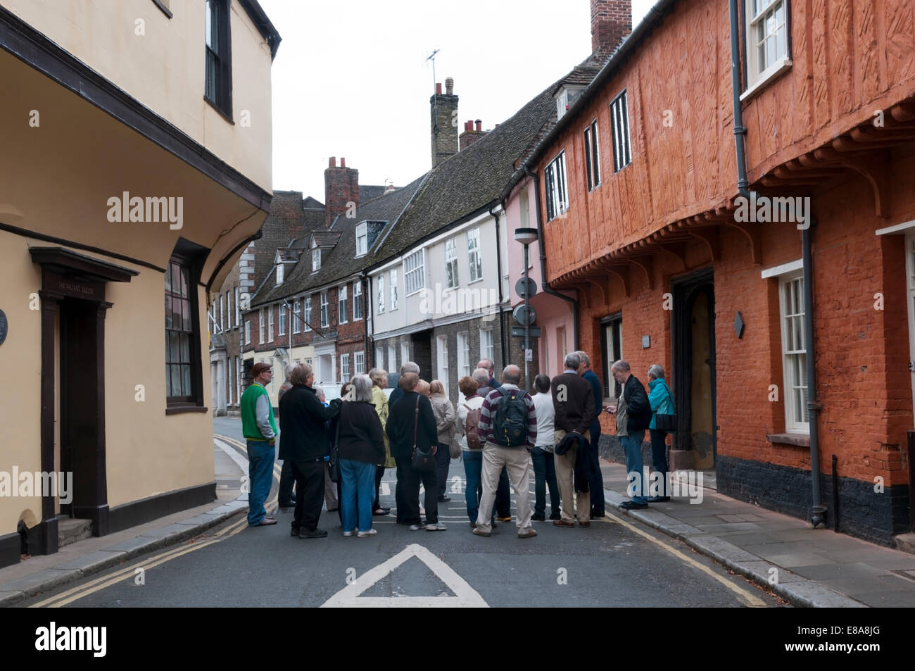 A guided walking tour around the historic old town of King's Lynn pauses to listen to a guide in Nelson Street. Stock Photo