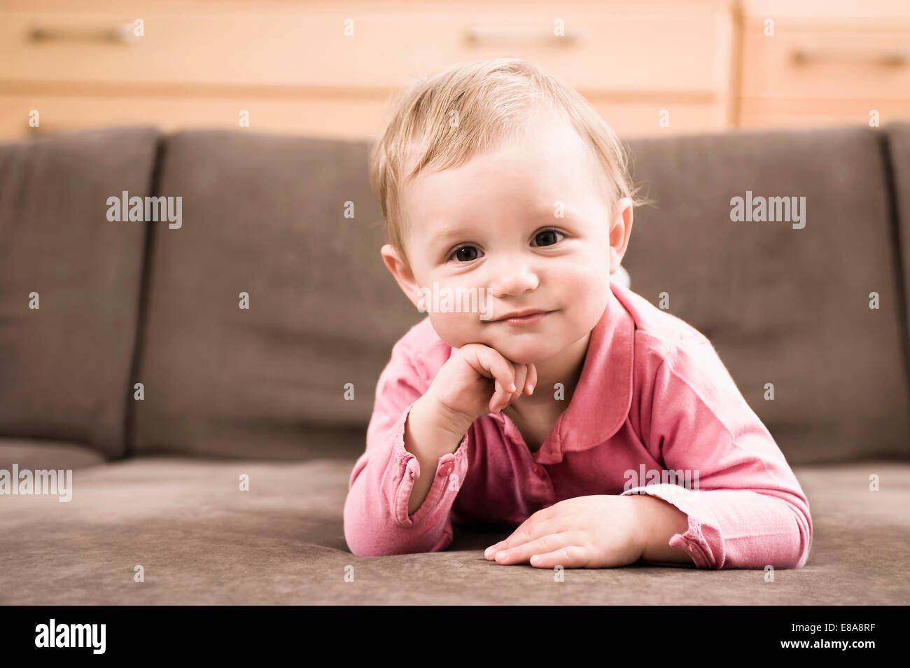 Portrait baby girl 18 months old lying on sofa Stock Photo Alamy