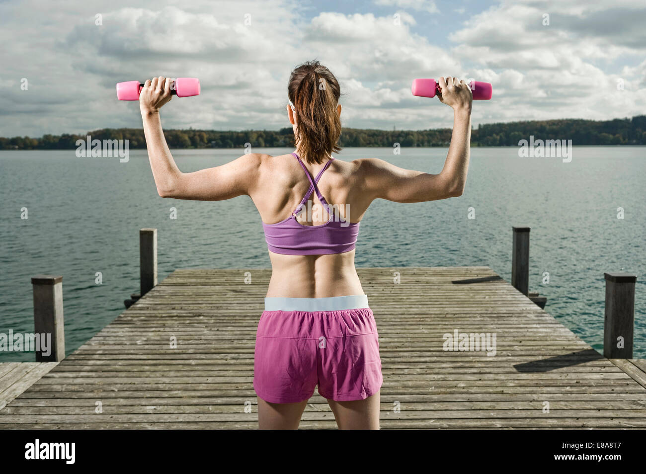 Woman training with dumbbells, Woerthsee, Bavaria, Germany Stock Photo