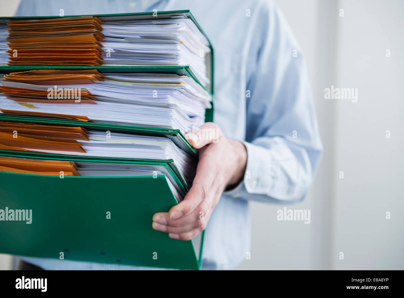 Close up man carrying pile filing folders Stock Photo