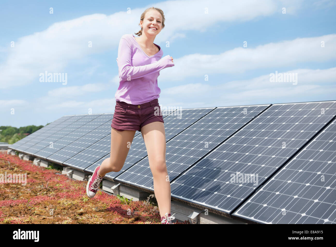 Young teenage girl jogging solar park Stock Photo