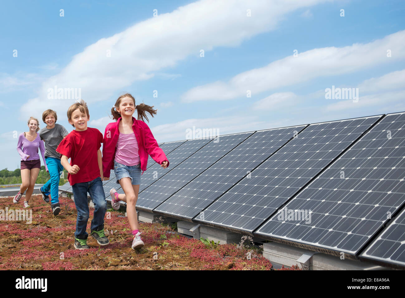 Group kids jogging solar panel park Stock Photo