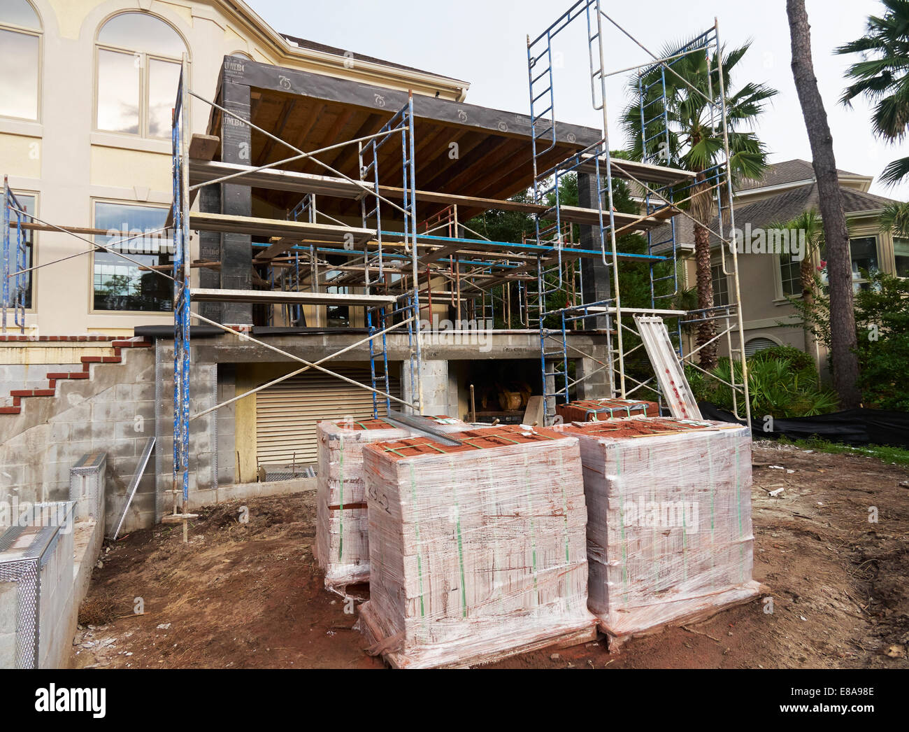 A house extension being built with scaffolding and a delivery of bricks. Stock Photo