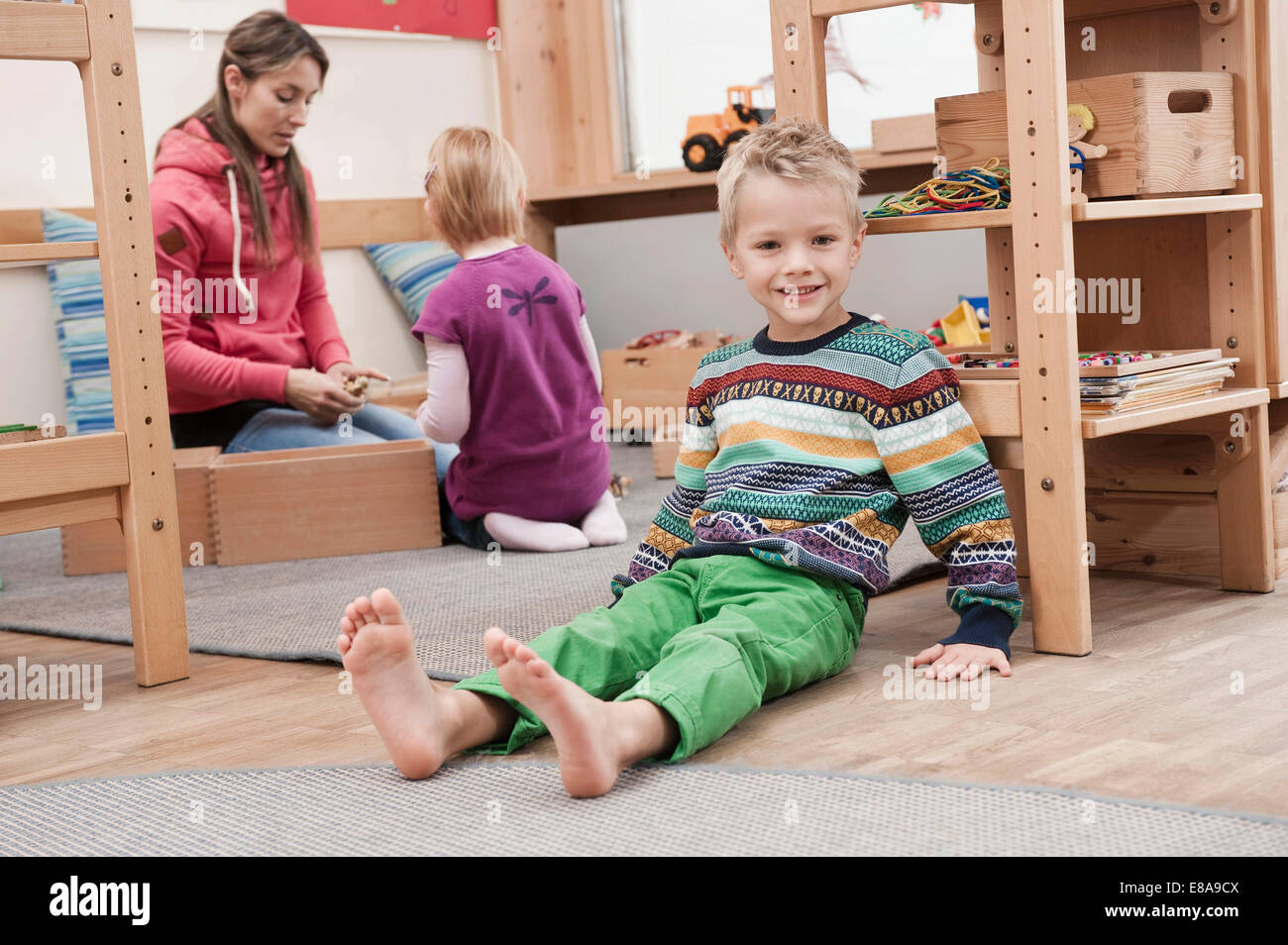 Little boy sitting on the ground in his kindergarten Stock Photo