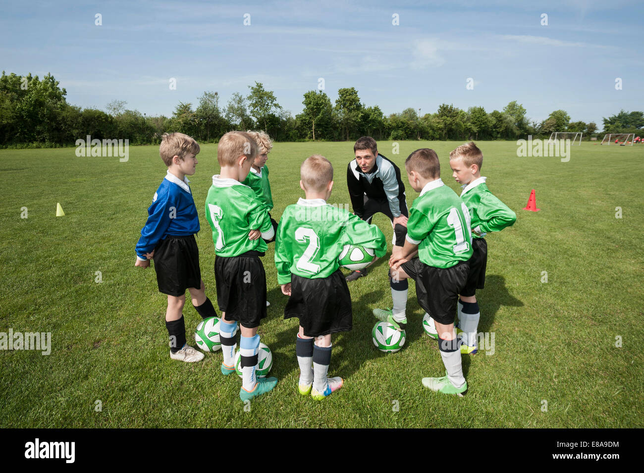 Trainer talking tactic kids junior football team Stock Photo