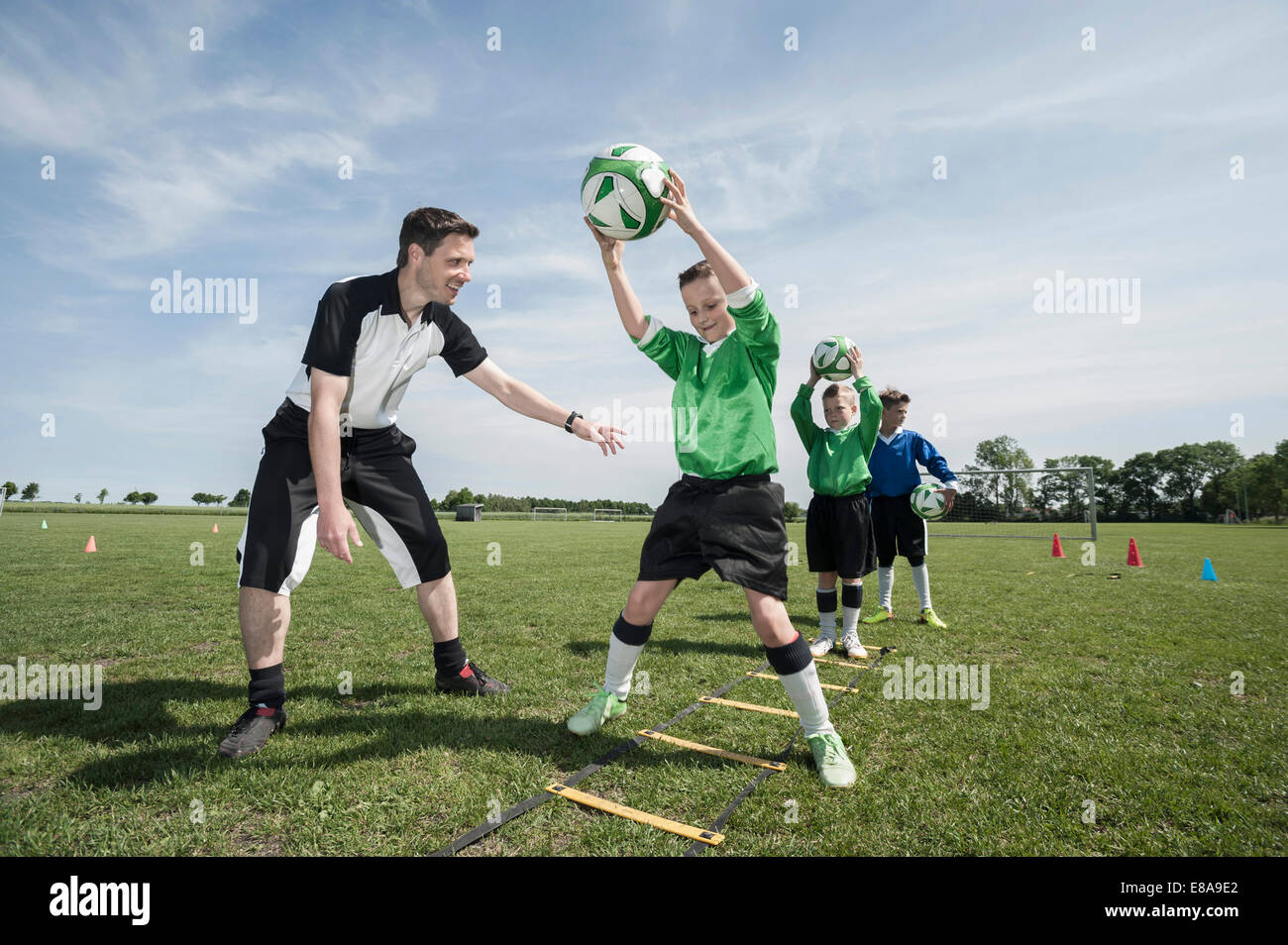 Soccer trainer teaching young players Stock Photo Alamy
