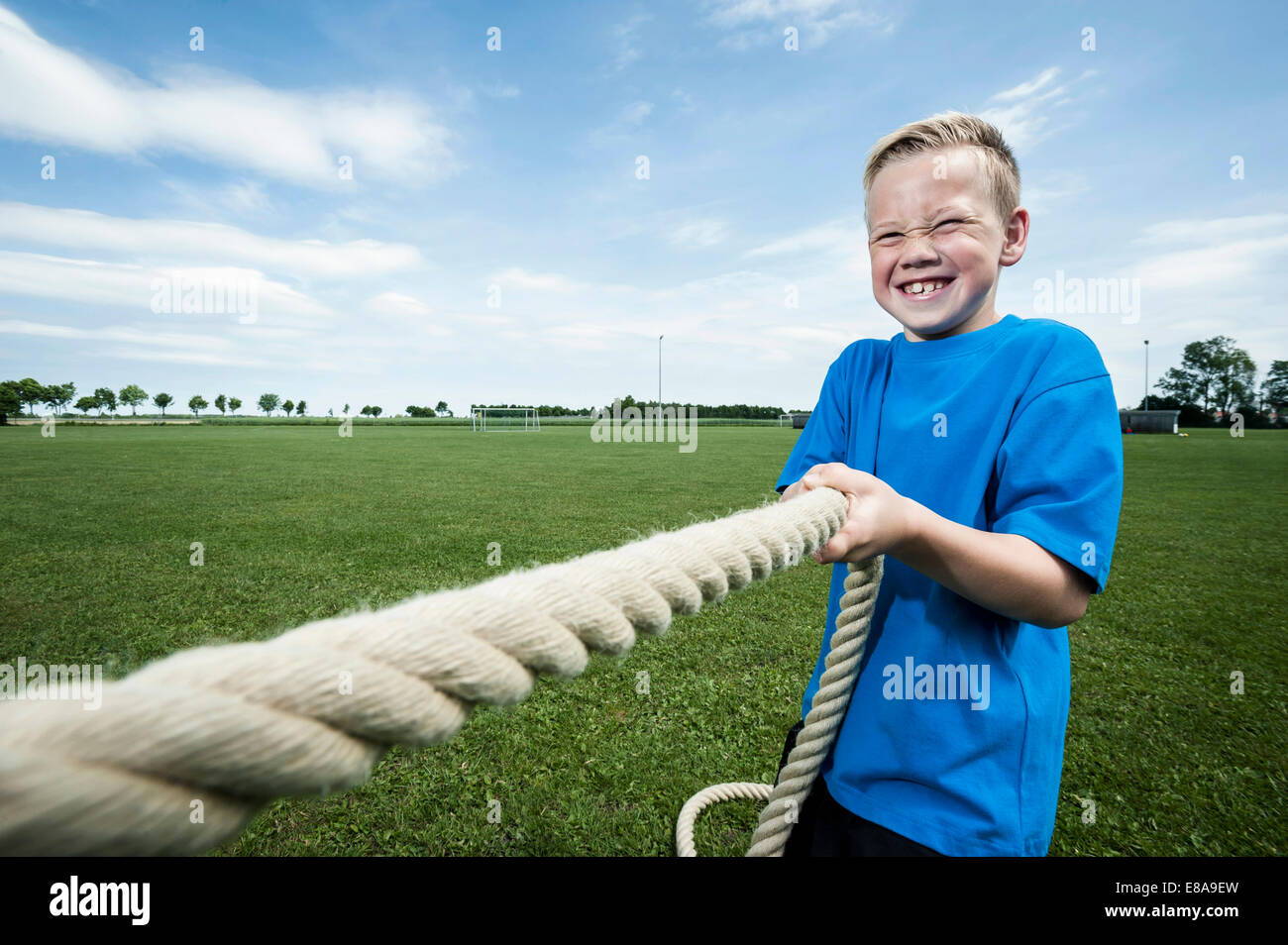 Young strong boy holding rope Tug-of-war strength Stock Photo