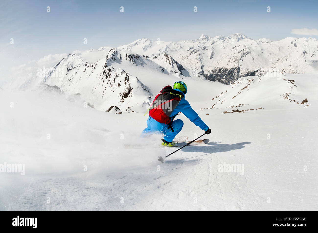Man skier skiing downhill steep slope mountains Stock Photo