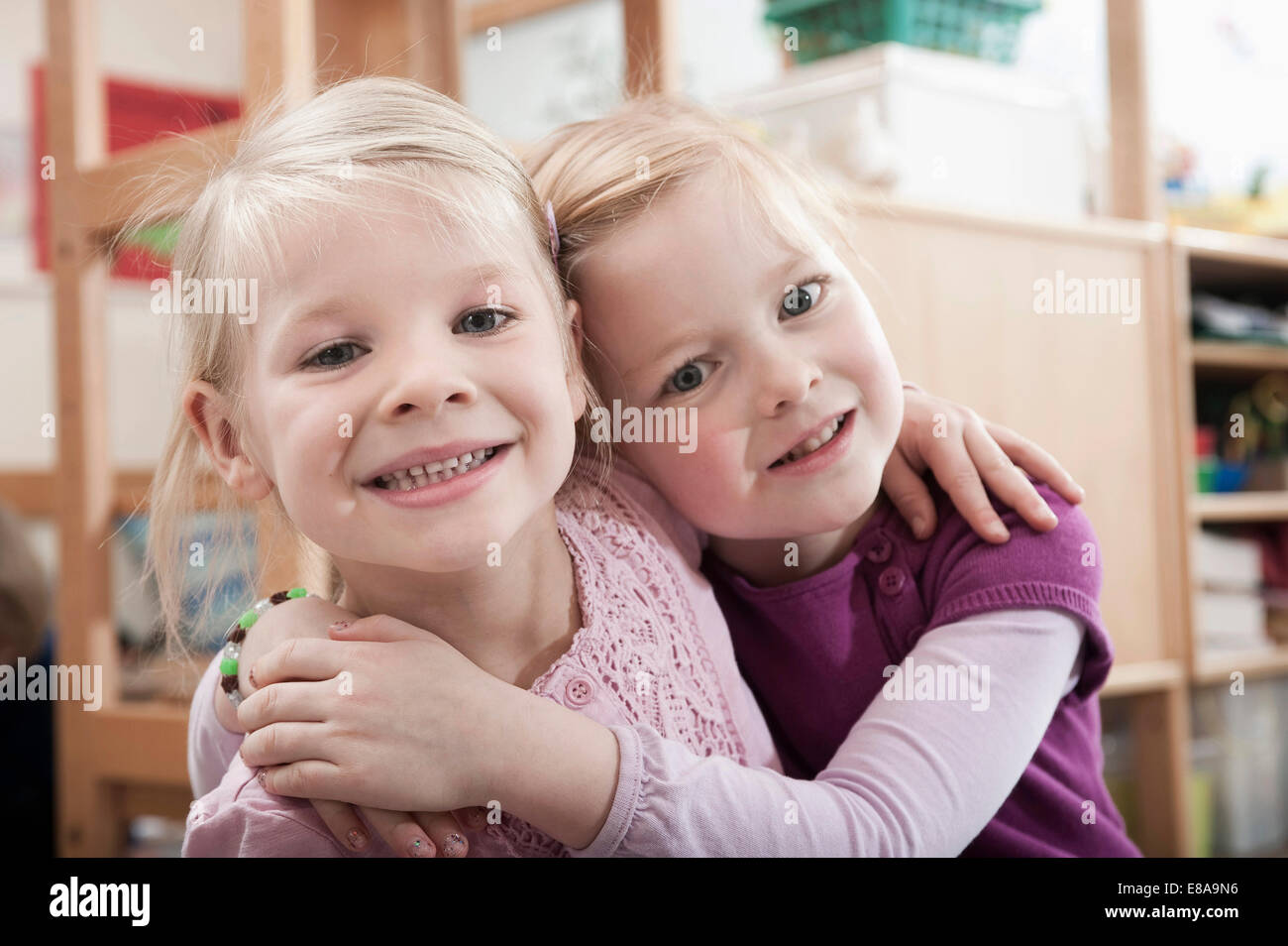 Portrait of two little girls, best friends, side by side in kindergarten Stock Photo