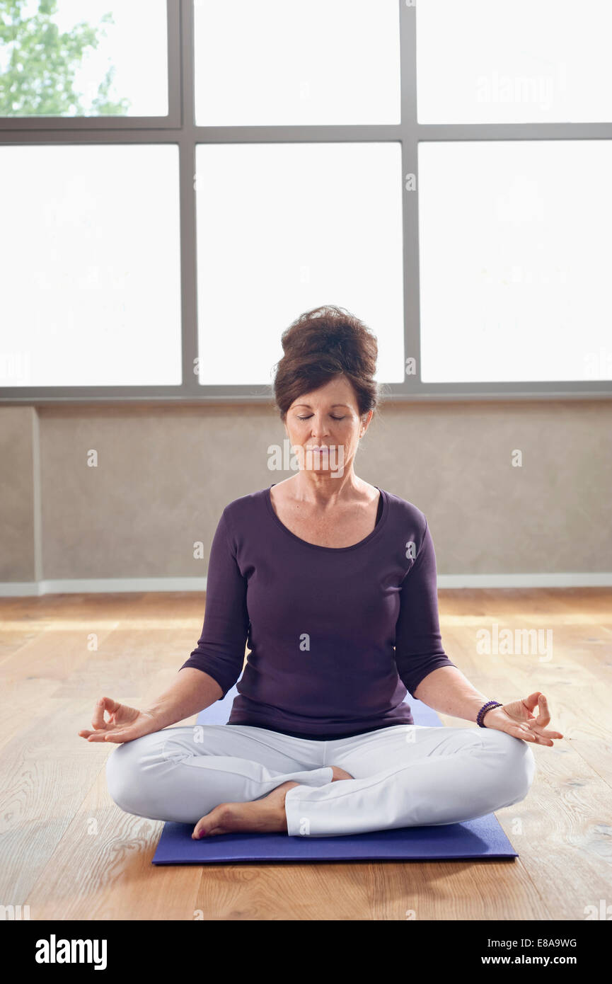 Mature woman yoga pose meditation eyes closed Stock Photo