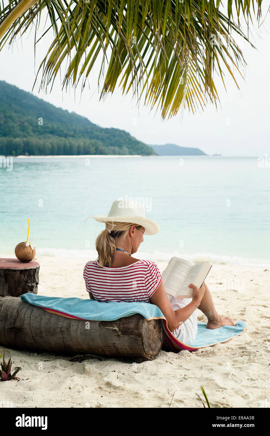 woman reading a book on the beach, Koh Lipe, Thailand Stock Photo