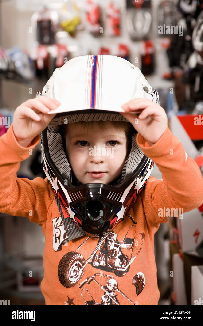 Boy with bicycle helmet in bike shop Stock Photo Alamy