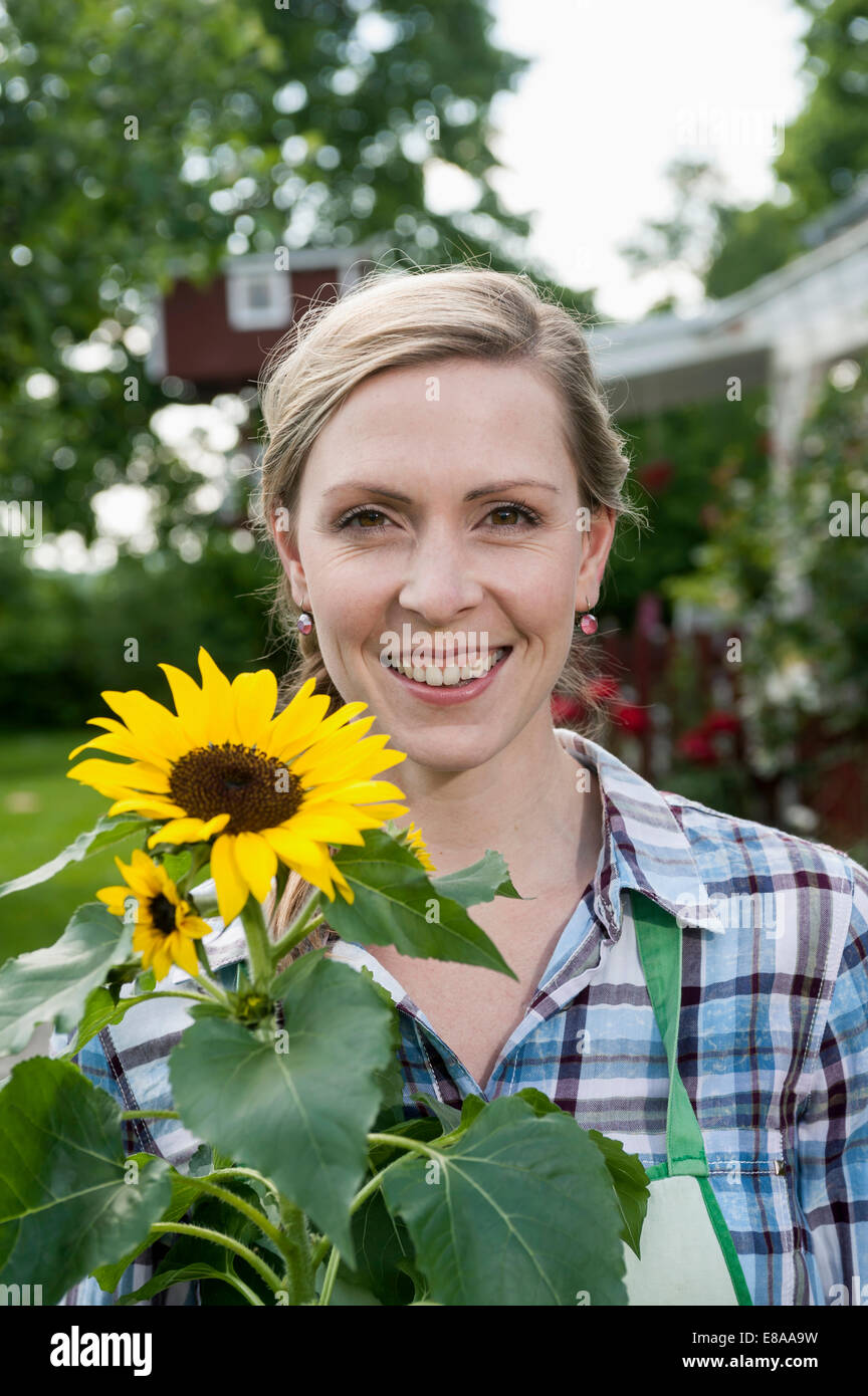 Portrait woman holding sunflower smiling Stock Photo - Alamy