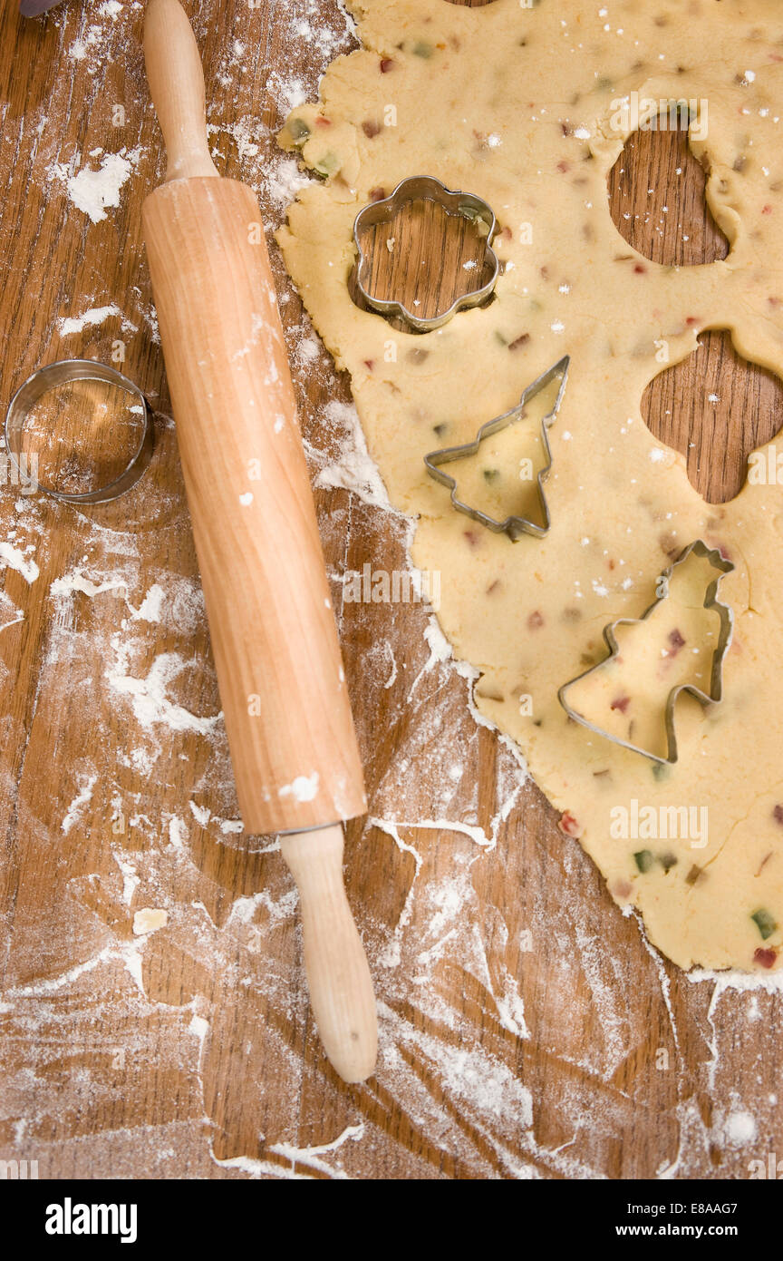 Dough with cookie cutters and rolling pin on wooden table Stock Photo