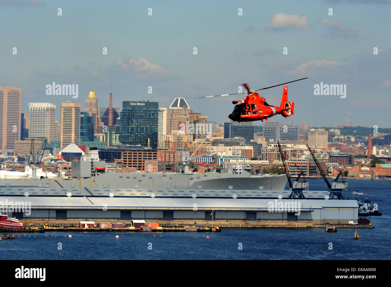 A U.S. Coast Guard MH-65 Dolphin helicopter assigned to Coast Guard Air Station Atlantic City, N.J., flies over the Inner Harbor in Baltimore Sept. 16, 2014, as visiting vessels leave the city following the Star-Spangled Spectacular, an event that commemo Stock Photo