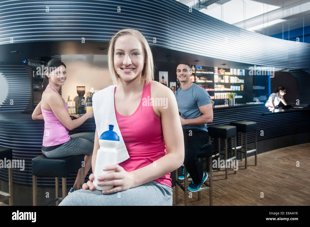 Smiling young woman at the bar of a gym Stock Photo