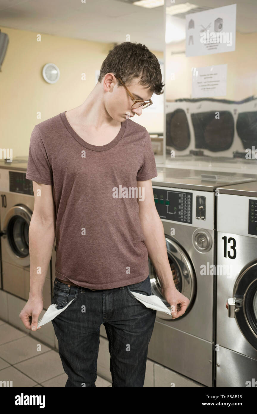 Young man pulling his empty pockets Stock Photo