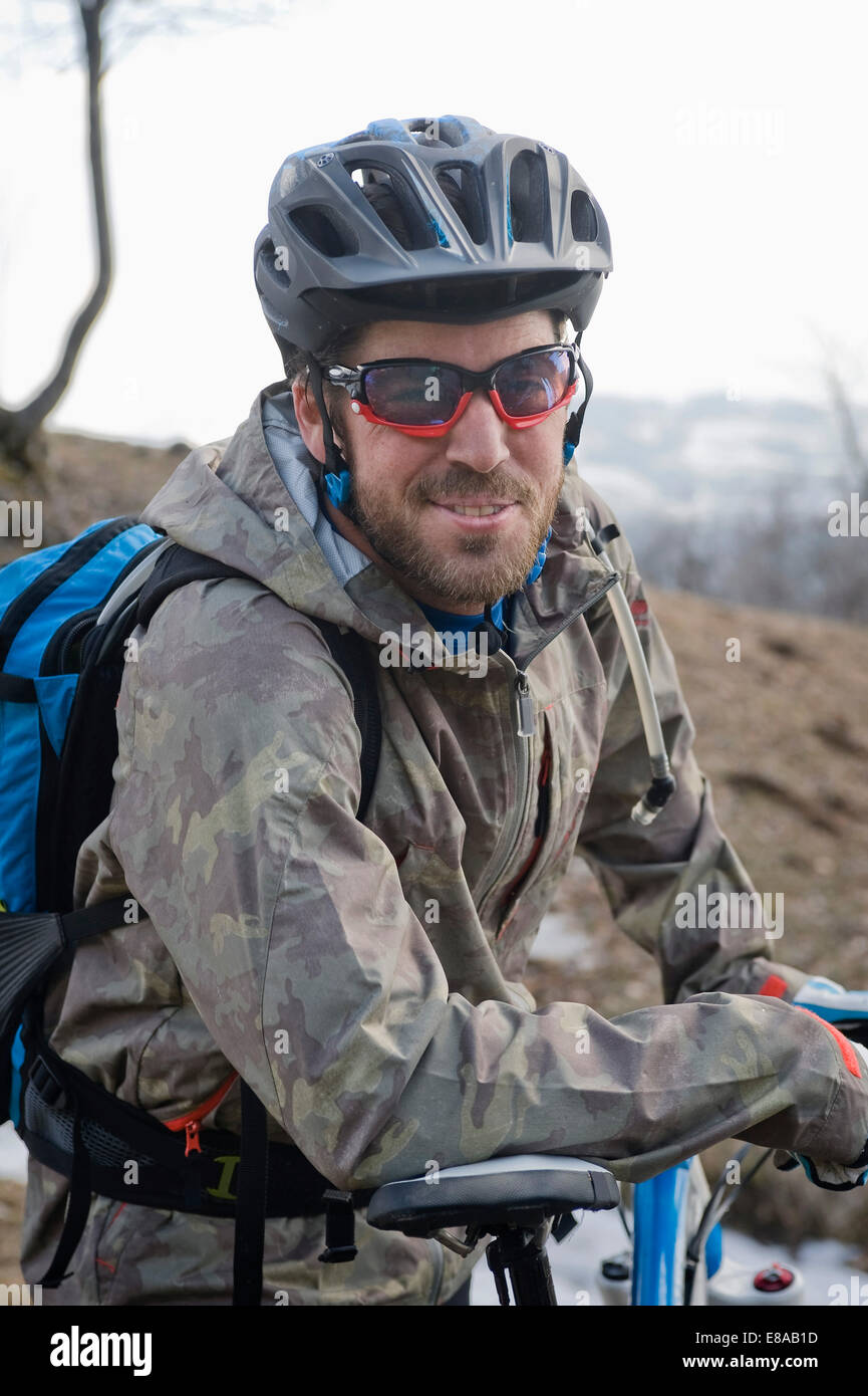Mid adult man with mountain bike, smiling, Italy Stock Photo