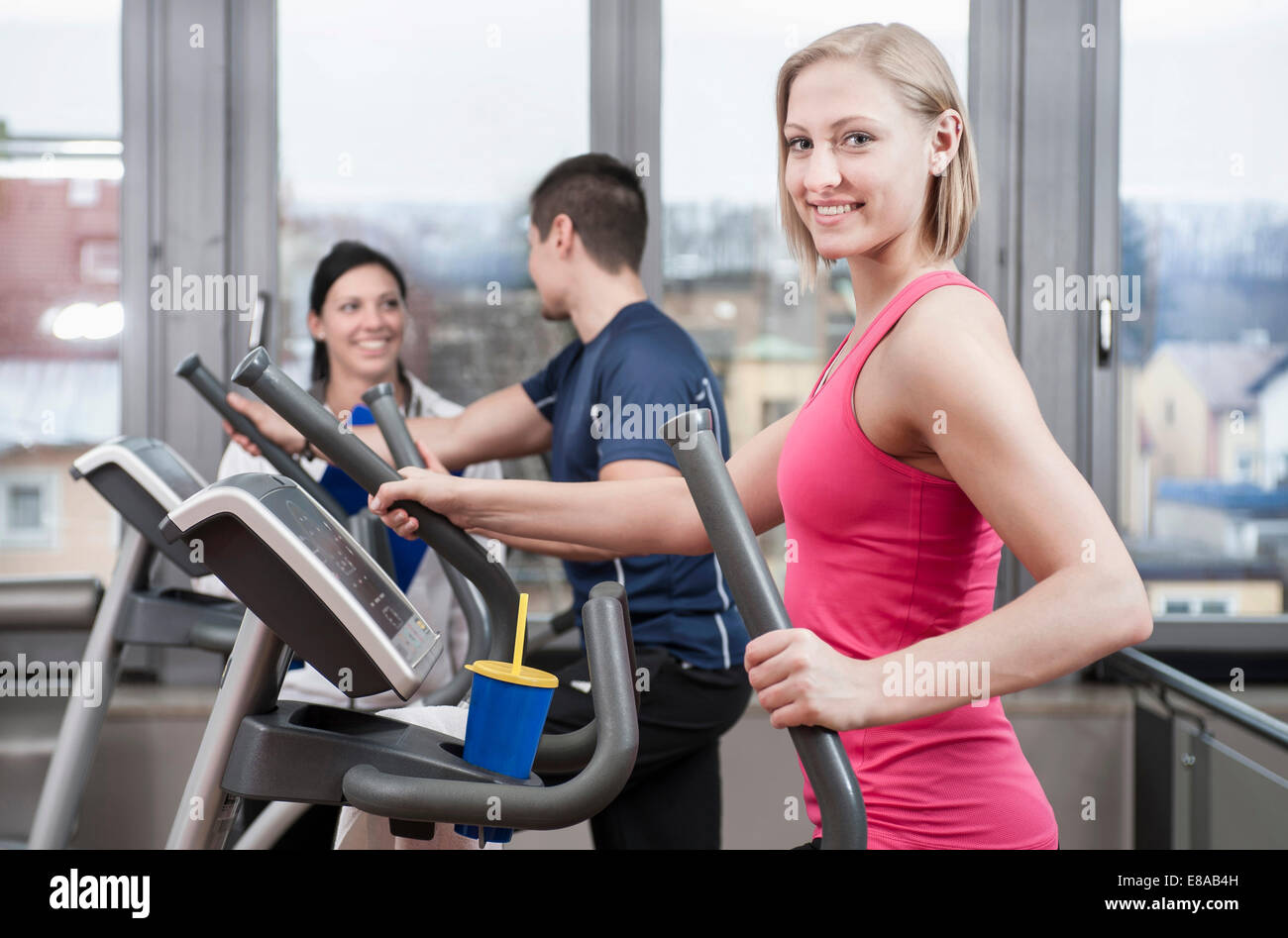 Young woman on elliptical trainer in gym Stock Photo - Alamy