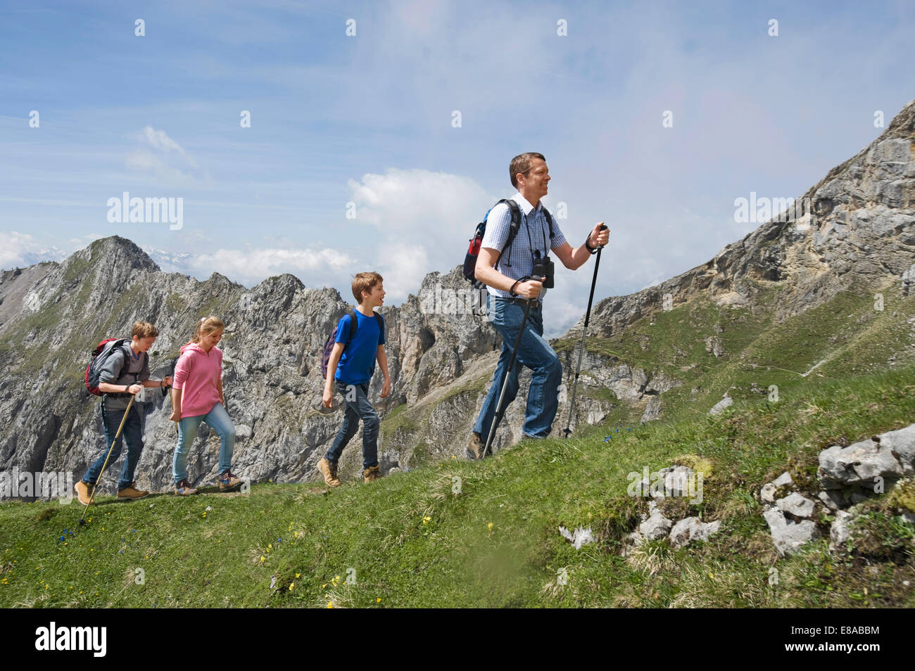 Father teenage kids hiking in mountains Alps Stock Photo