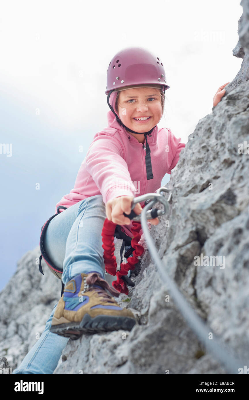 Teenage girl climbing attaching carabiner to rope Stock Photo Alamy