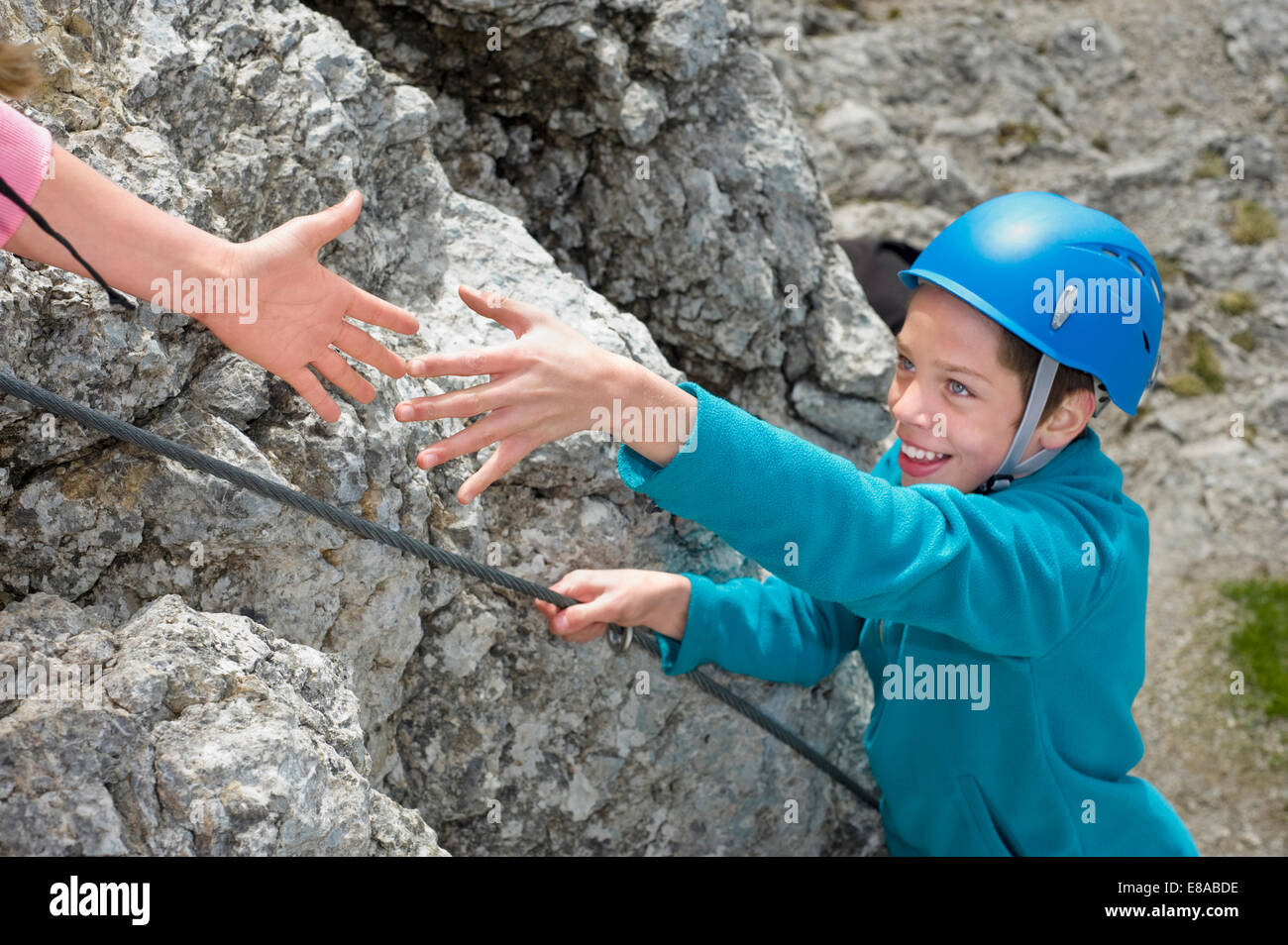 Hand helping teenage boy climbing Alps reaching Stock Photo Alamy