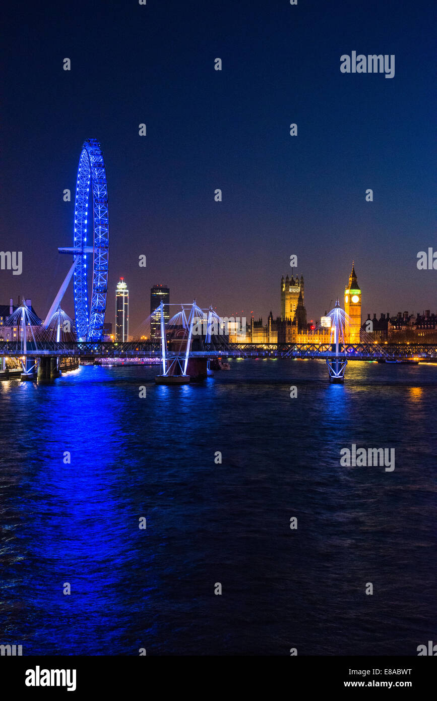 View at dusk towards The London Eye, The Palace of Westminster, Hungerford Bridge and Golden Jubilee Bridges, London, UK Stock Photo