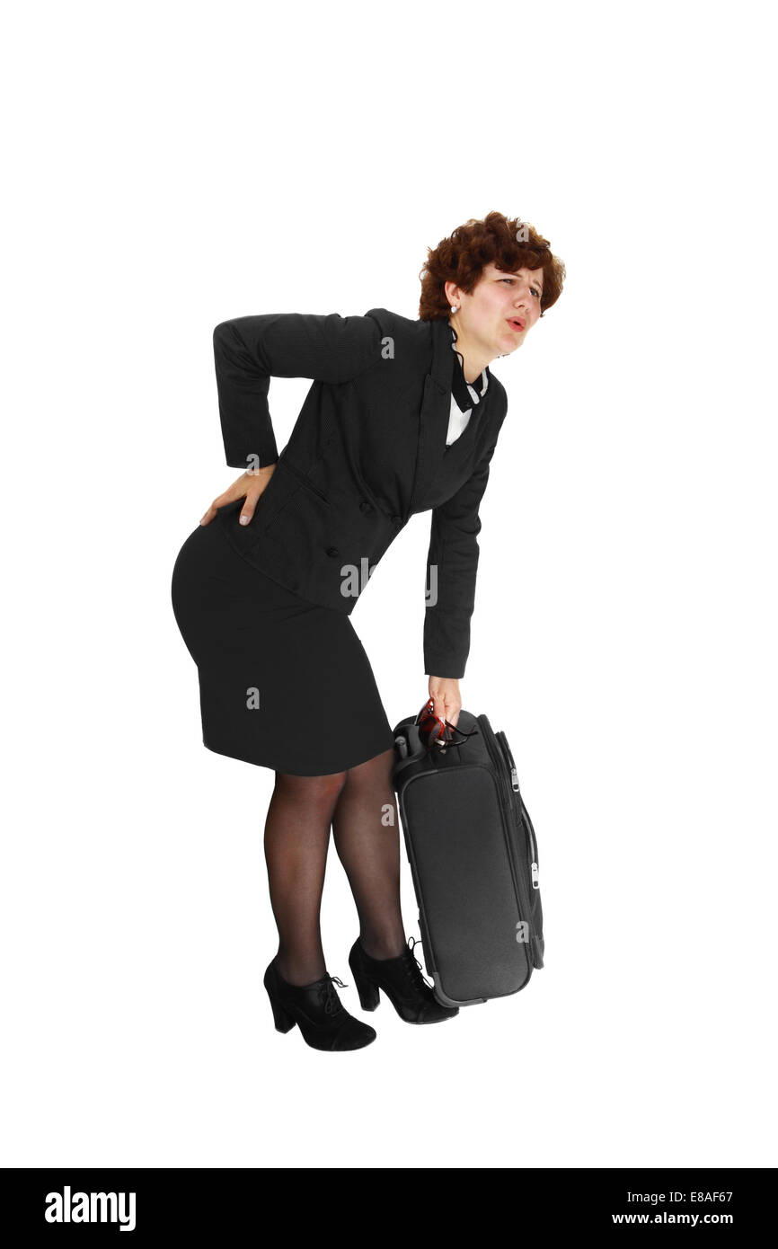 Young woman suffers from back pain lifting a heavy suitcase isolated on
