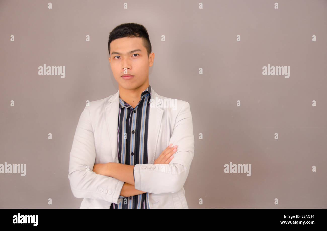 young Asian business man on brown background Stock Photo