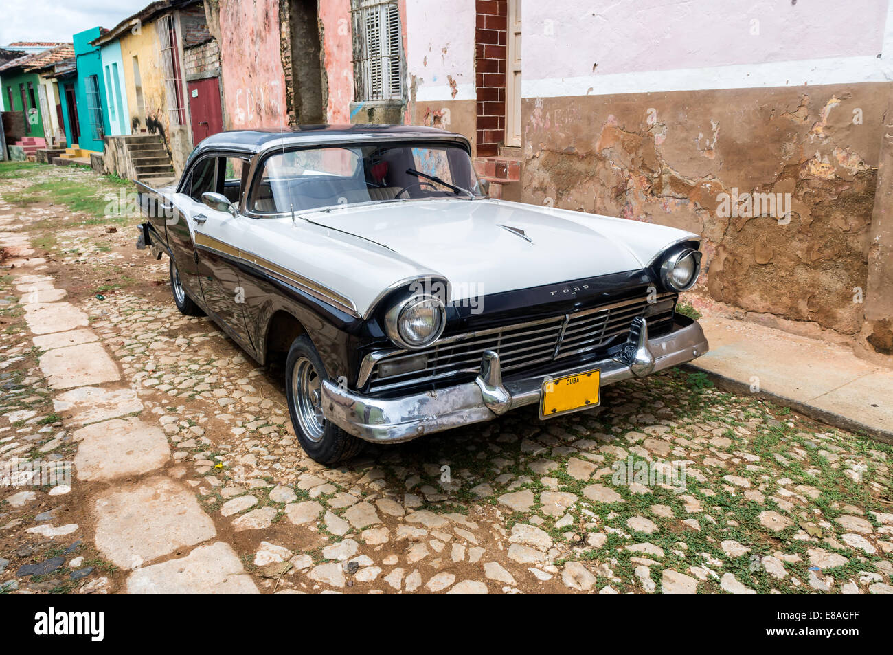 Street scene with vintage car and worn out buildings in Trinidad, Cuba. Stock Photo