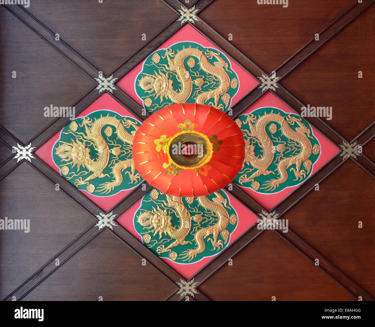 Red lantern and dragon motifs on ceiling of Buddhist temple Stock Photo